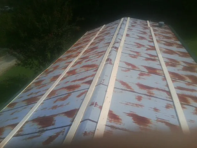 Rusted metal roof panels with new wood purlins before replacement — Storm Damage Roof Repair in Reeseville by Roofing Brothers