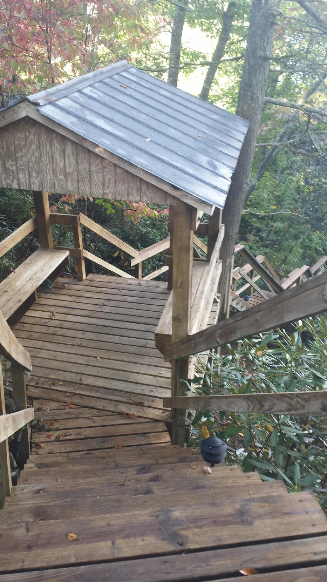 Metal roofed shelter over wooden steps on a wooded walkway — Skylight Repair & Installation work by our crew in Reeseville