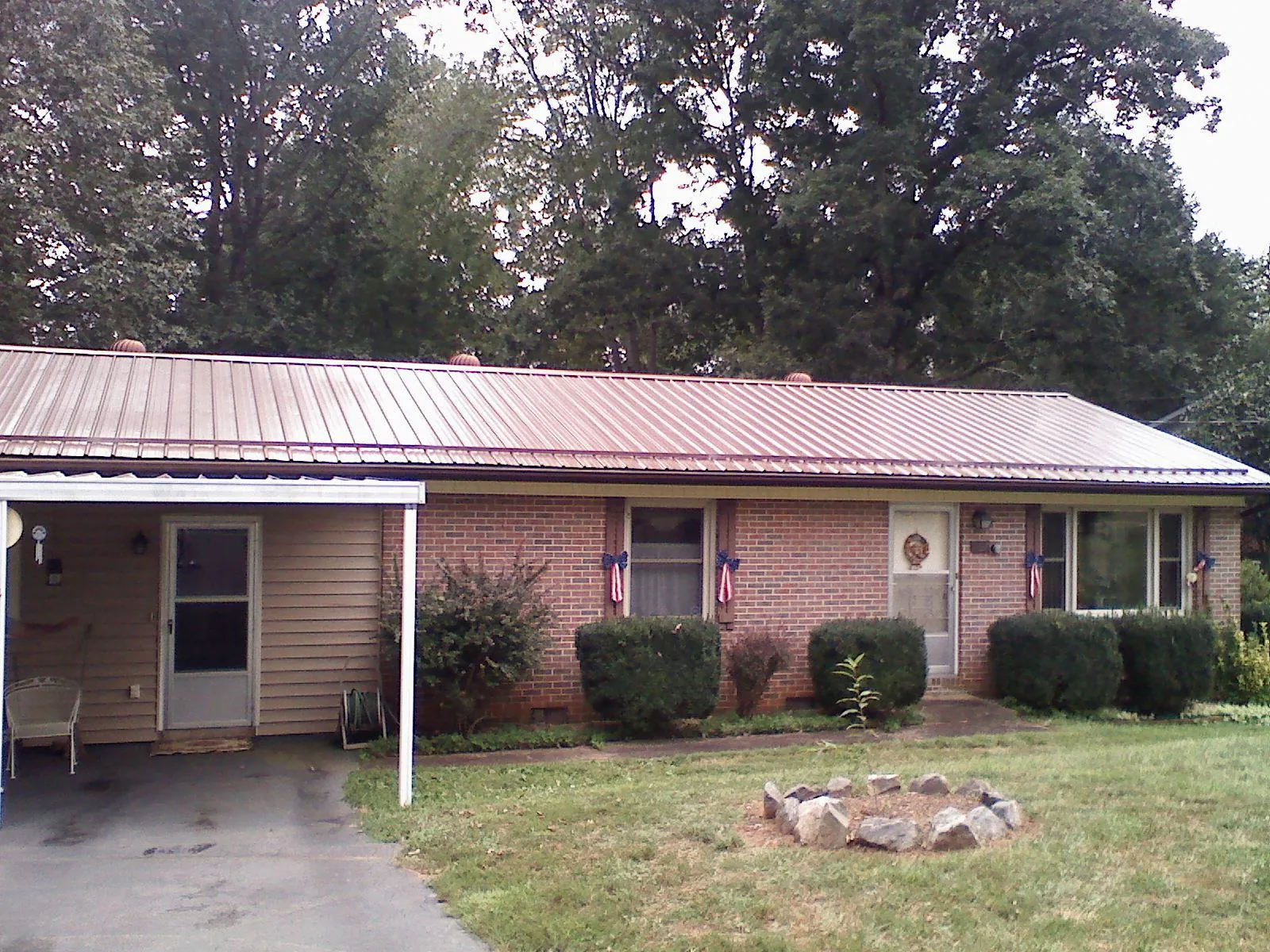 Bronze metal roof and carport on a brick ranch home — Roof Repair work by our crew in Reeseville